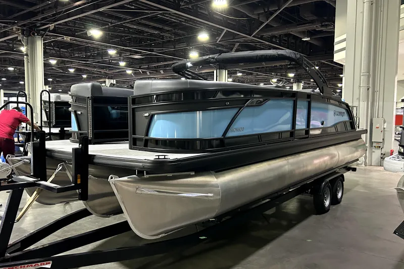 Slide: The Image of 2026 Godfrey Monaco 255 SFL pontoon boat displayed indoors on a trailer. - 1