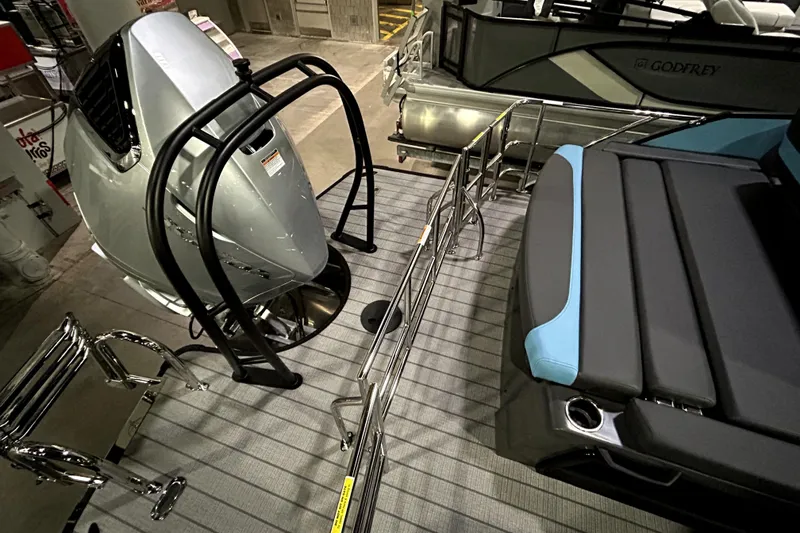 Slide: The Image of 2026 Godfrey Monaco 255 SFL boat interior with engine and seating area. - 12