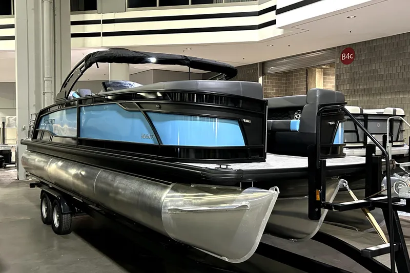 Slide: The Image of 2026 Godfrey Monaco 255 SFL pontoon boat displayed indoors on a trailer. - 2
