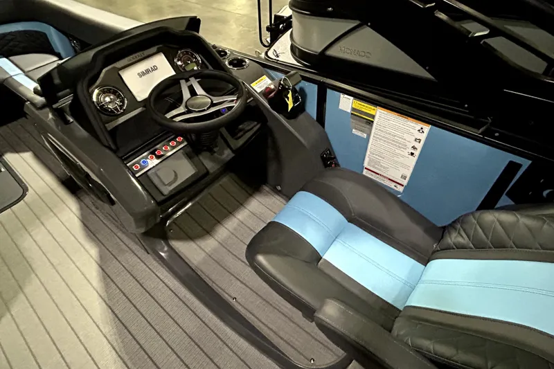 Slide: The Image of 2026 Godfrey Monaco 255 SFL boat interior with steering wheel and blue-accented seats. - 8
