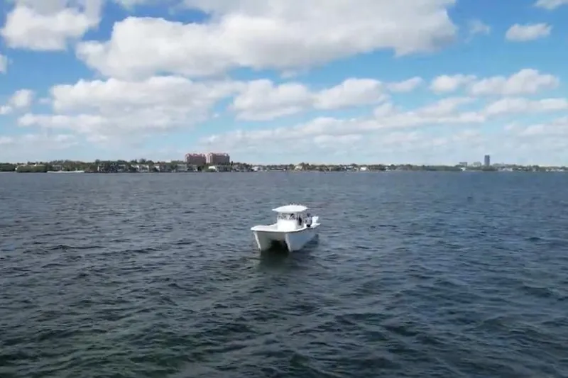 Slide: The Image of 2025 AmeraCat 39 boat cruising on a calm lake under a partly cloudy sky. - 12