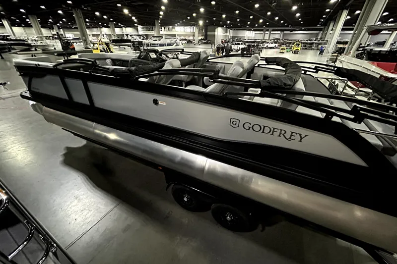 Slide: The Image of 2026 Godfrey Monaco 255 QSL pontoon boat displayed in a spacious indoor showroom. - 4