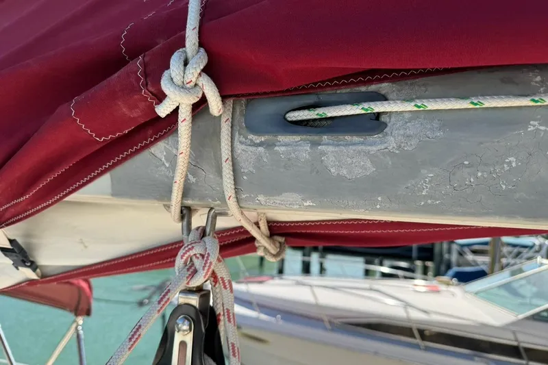 Slide: The Image of Close-up of 1989 Island Packet 35 sailboat rigging with red sail cover and ropes. - 18