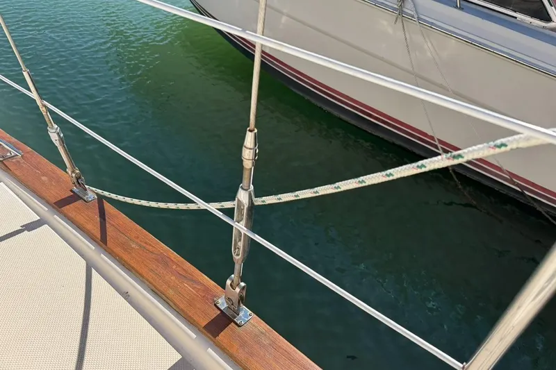 Slide: The Image of 1989 Island Packet 35 sailboat deck with railing and rigging over water. - 19