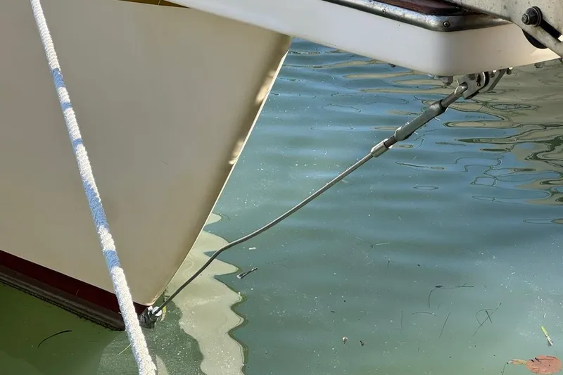 Slide: The Image of Bow of 1989 Island Packet 35 sailboat with anchor chain in calm water. - 23
