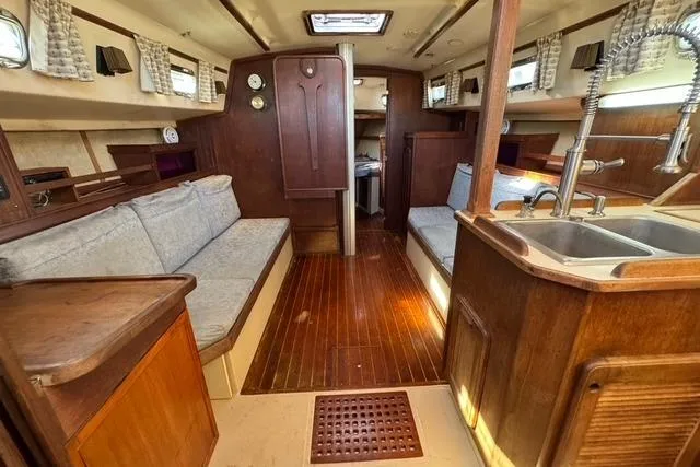 Slide: The Image of Interior of 1989 Island Packet 35 sailboat with wooden finishes and cozy seating. - 24