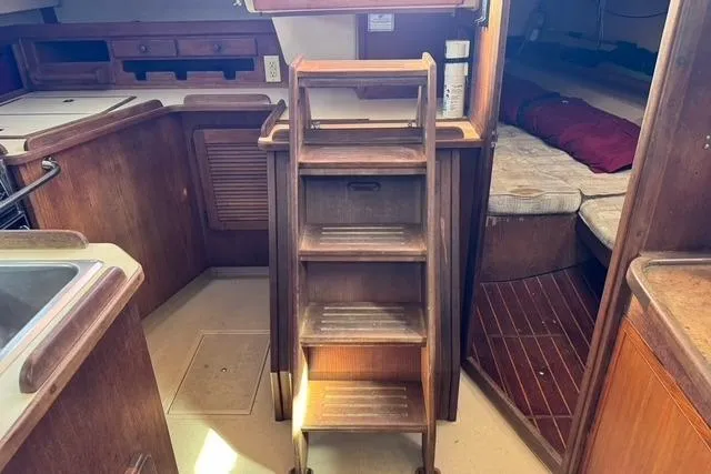 Slide: The Image of 1989 Island Packet 35 interior with wooden steps, kitchen, and cozy sleeping area. - 27