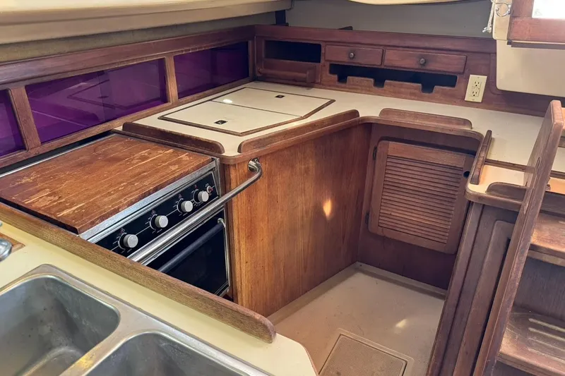 Slide: The Image of 1989 Island Packet 35 yacht kitchen with wooden cabinetry and stove. - 29