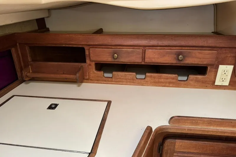 Slide: The Image of Interior of 1989 Island Packet 35 sailboat with wooden cabinetry and electrical outlet. - 34