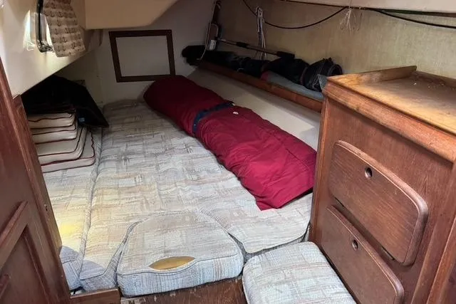Slide: The Image of 1989 Island Packet 35 sailboat cabin with cozy sleeping area and wooden storage. - 36