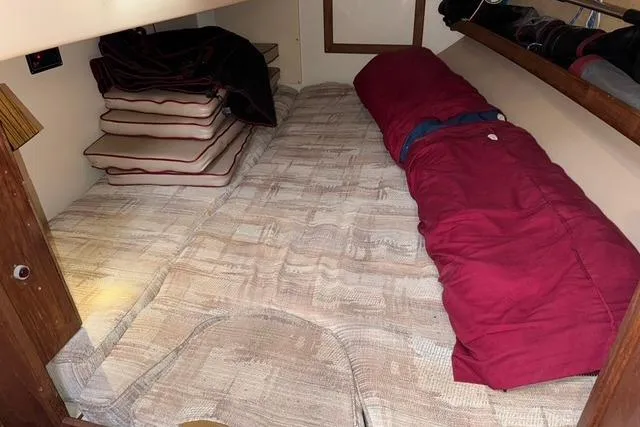 Slide: The Image of 1989 Island Packet 35 sailboat cabin with cushions and red sleeping bag. - 37