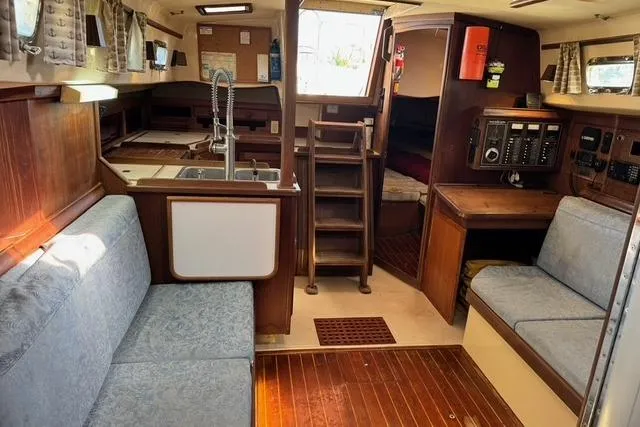 Slide: The Image of Interior of 1989 Island Packet 35 sailboat with cozy seating and wooden finishes. - 38