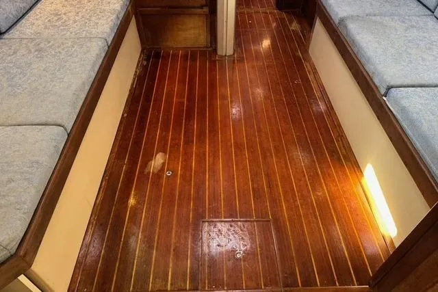 Slide: The Image of 1989 Island Packet 35 interior with polished wooden flooring and cushioned seating. - 39