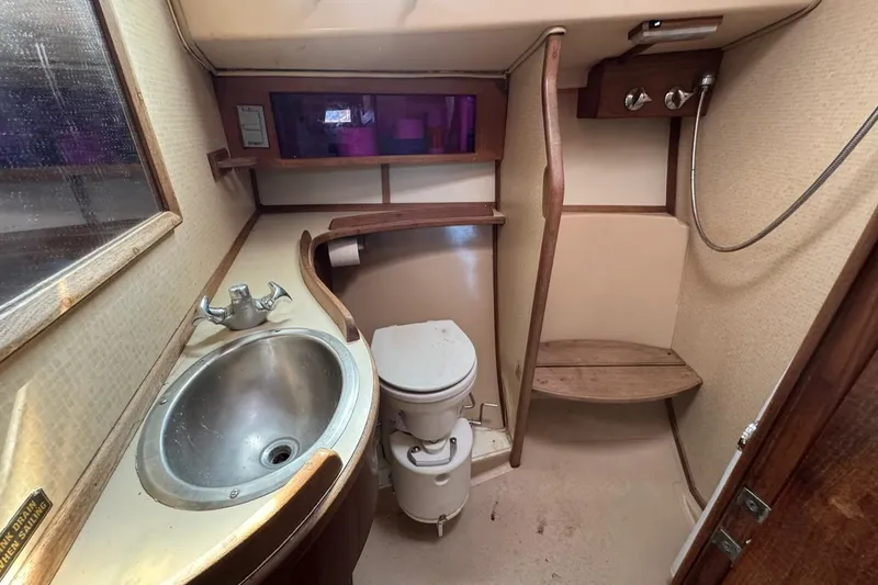 Slide: The Image of 1989 Island Packet 35 yacht bathroom with sink, toilet, and shower area. - 41