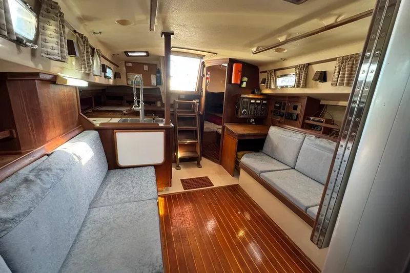 Slide: The Image of Interior of 1989 Island Packet 35 sailboat with cozy seating and wooden finishes. - 42