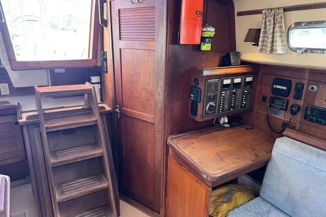 Slide: The Image of Interior of 1989 Island Packet 35 sailboat with wooden cabinetry and navigation equipment. - 43