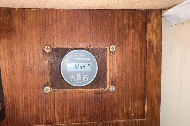 Slide: The Image of Voltage meter displaying 12.59V on 1989 Island Packet 35 sailboat wooden panel. - 45