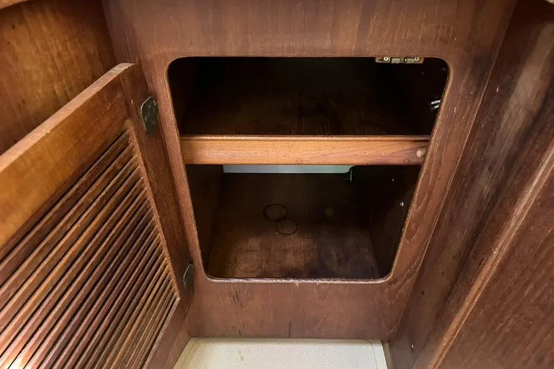 Slide: The Image of Empty wooden cabinet inside a 1989 Island Packet 35 sailboat. - 51