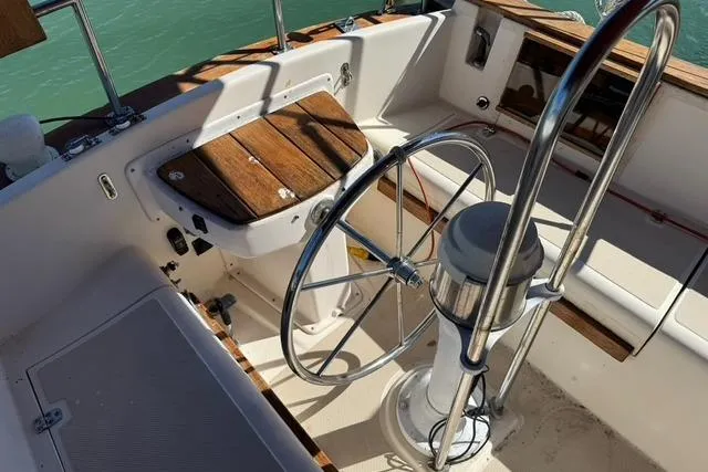 Slide: The Image of Cockpit of 1989 Island Packet 35 sailboat with steering wheel and wooden accents. - 8