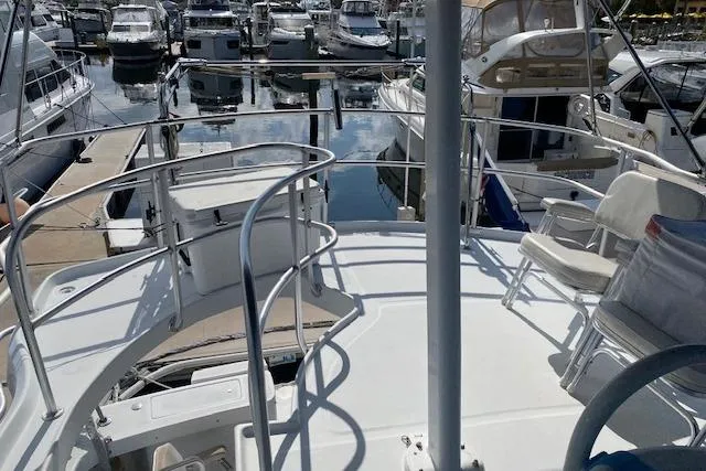 Slide: The Image of 1999 Mainship 350 Trawler docked at marina, surrounded by other boats. - 10