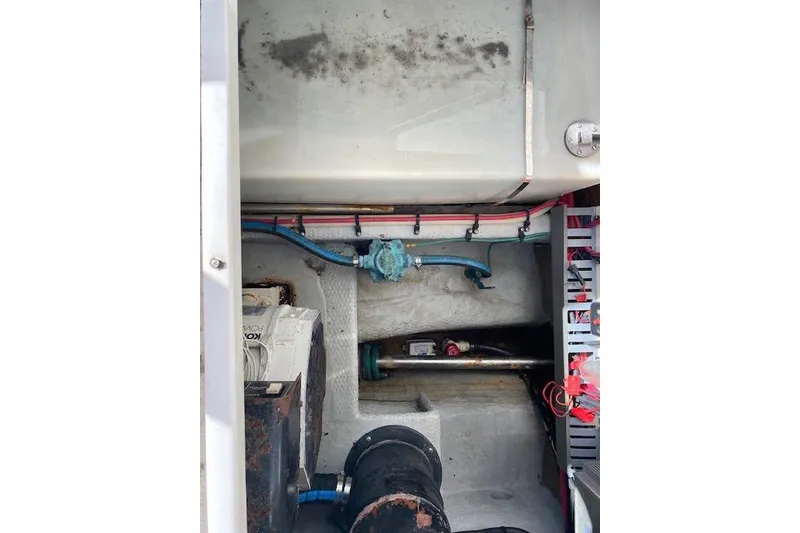 Slide: The Image of Engine compartment of a 1999 Mainship 350 Trawler, showing mechanical components and wiring. - 12