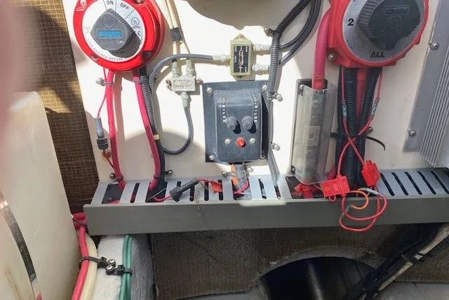 Slide: The Image of Electrical panel of a 1999 Mainship 350 Trawler with wiring and switches. - 13