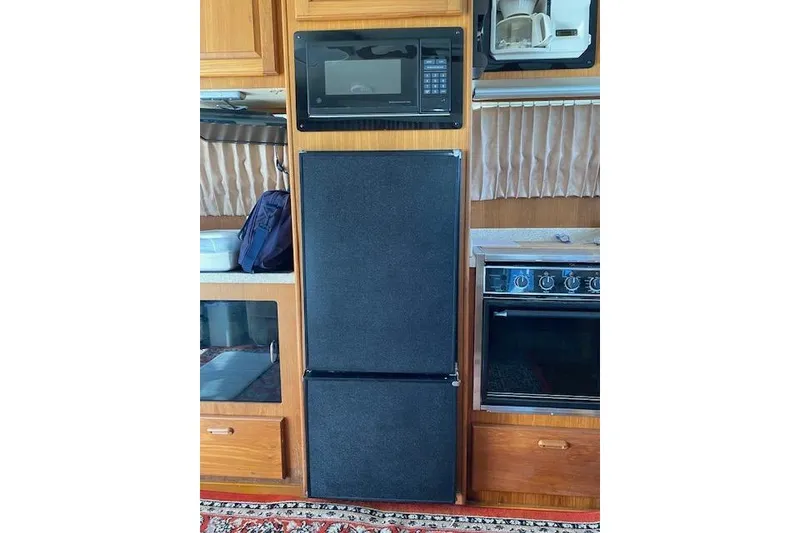 Slide: The Image of 1999 Mainship 350 Trawler kitchen with microwave, fridge, and stove. - 17