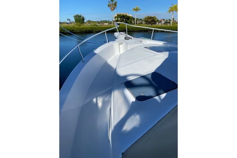 Slide: The Image of 1999 Mainship 350 Trawler deck view with railing, calm water, and clear sky. - 20