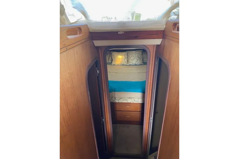 Slide: The Image of Interior cabin of 1999 Mainship 350 Trawler with cozy bedding and wooden cabinetry. - 28