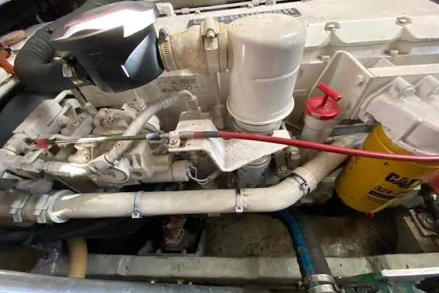 Slide: The Image of Engine compartment of a 1999 Mainship 350 Trawler, showcasing mechanical components and filters. - 36