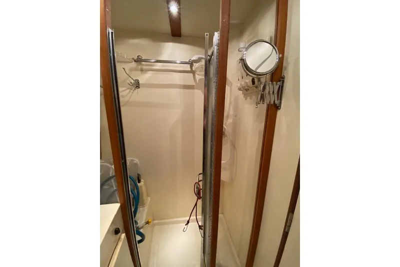 Slide: The Image of 1999 Mainship 350 Trawler bathroom with shower, mirror, and wooden accents. - 39