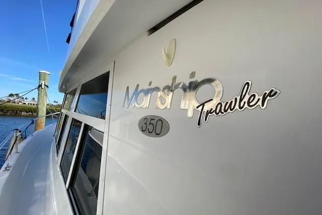 Slide: The Image of 1999 Mainship 350 Trawler boat side view with logo and windows. - 41