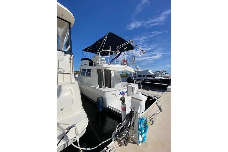 Slide: The Image of 1999 Mainship 350 Trawler docked at marina under clear blue sky. - 42