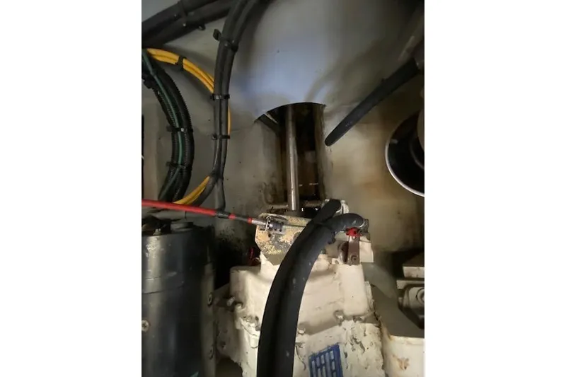 Slide: The Image of Engine room of a 1999 Mainship 350 Trawler with visible cables and machinery. - 49