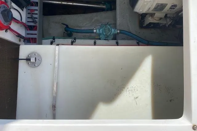 Slide: The Image of Engine compartment of a 1999 Mainship 350 Trawler, showcasing mechanical components and wiring. - 54