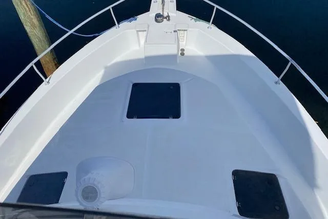 Slide: The Image of 1999 Mainship 350 Trawler boat deck with hatches, docked on calm water. - 6