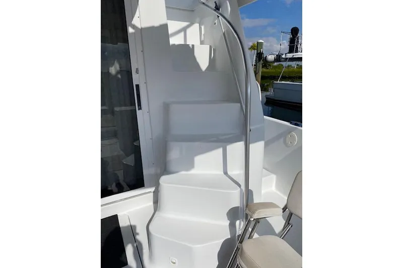 Slide: The Image of Staircase on 1999 Mainship 350 Trawler, featuring white steps and metal railing. - 8