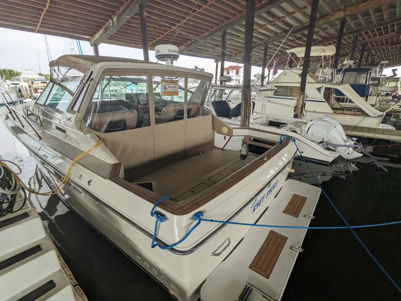 Slide: The Image of 1988 Sea Ray 390 Express Cruiser docked in a marina under a covered shelter. - 10