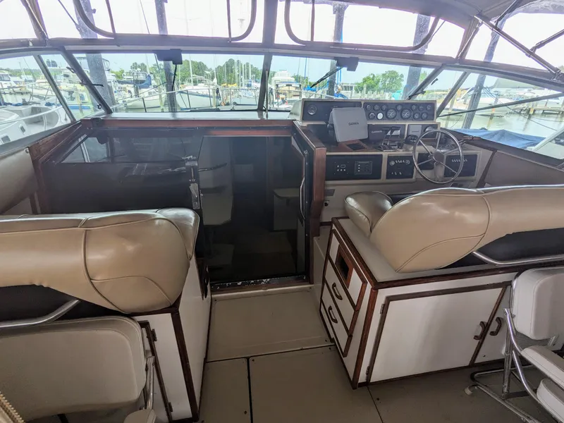 Slide: The Image of 1988 Sea Ray 390 Express Cruiser cockpit with beige seating and control panel. - 15