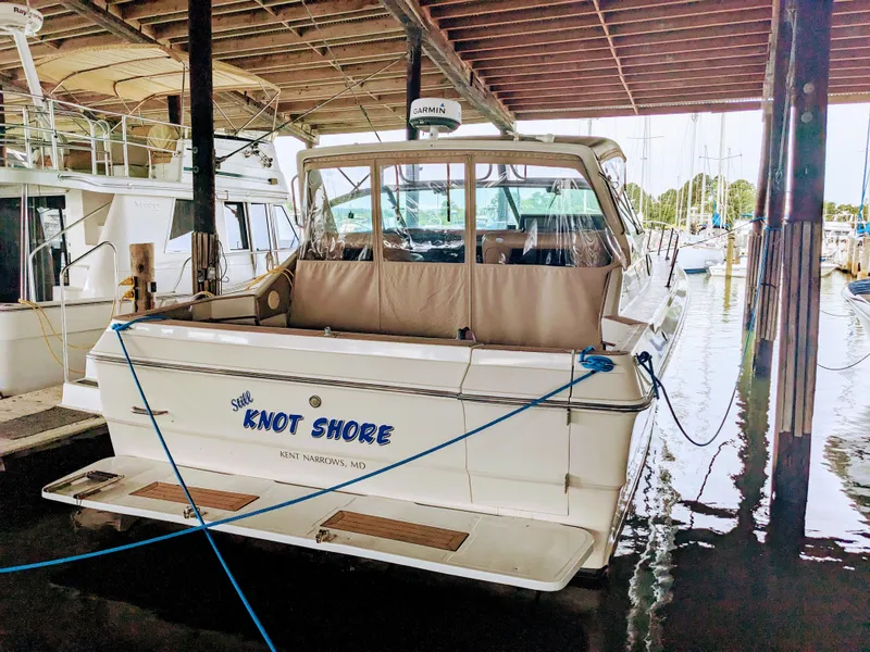 Slide: The Image of 1988 Sea Ray 390 Express Cruiser docked in marina, named "Knot Shore." - 2