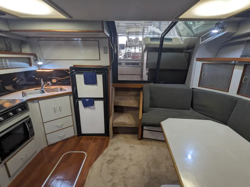 Slide: The Image of 1988 Sea Ray 390 Express Cruiser interior with kitchen, seating, and stairs. - 21