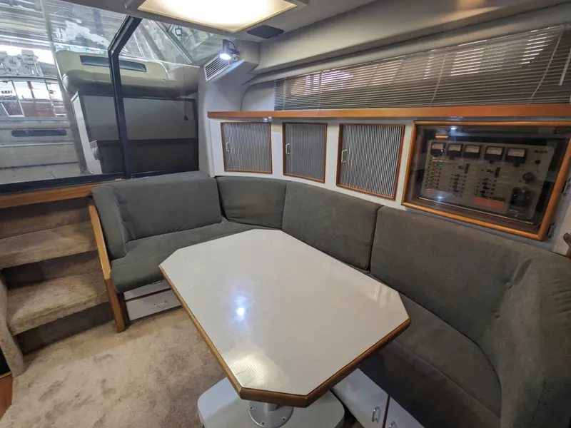 Slide: The Image of 1988 Sea Ray 390 Express Cruiser interior with gray seating and a central table. - 22