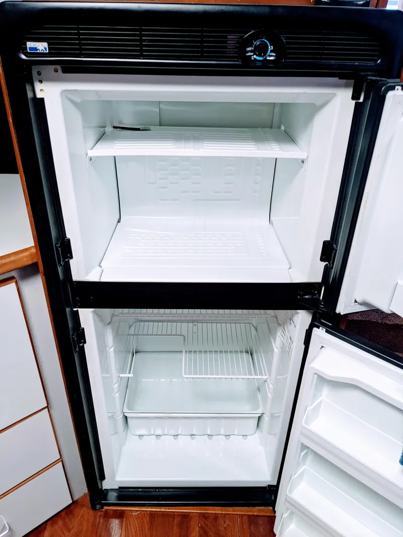 Slide: The Image of Empty refrigerator inside a 1988 Sea Ray 390 Express Cruiser boat. - 27