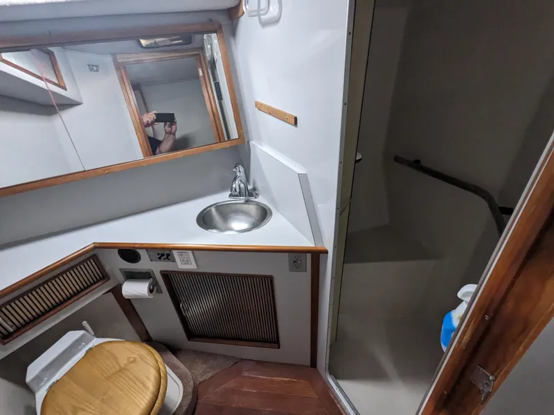 Slide: The Image of 1988 Sea Ray 390 Express Cruiser bathroom with sink, toilet, and shower. - 34