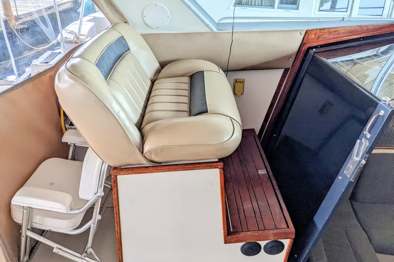 Slide: The Image of 1988 Sea Ray 390 Express Cruiser interior with beige seating and wooden accents. - 52