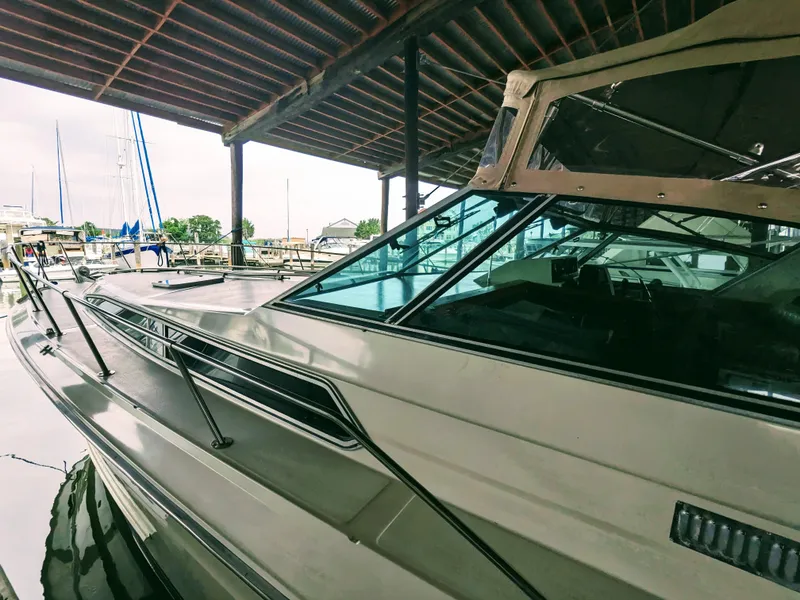 Slide: The Image of 1988 Sea Ray 390 Express Cruiser docked under a covered marina. - 6