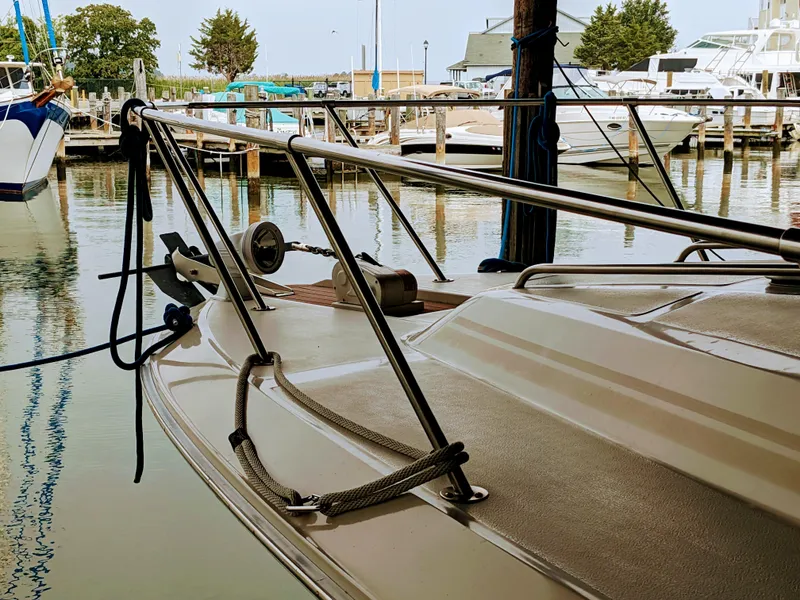 Slide: The Image of 1988 Sea Ray 390 Express Cruiser docked at marina, showcasing bow and railings. - 8