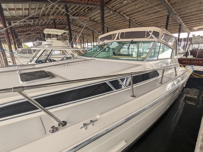Slide: The Image of 1988 Sea Ray 390 Express Cruiser docked in a covered marina, showcasing sleek design. - 9