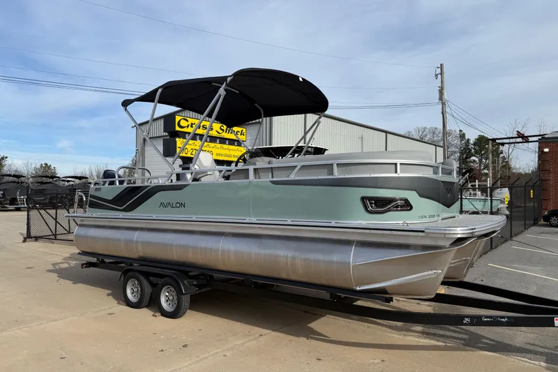 The Image of 2026 Avalon Venture 85 Versatile Rear Bench pontoon boat on trailer, outdoor display. - 0