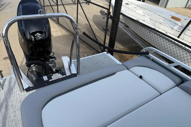 Slide: The Image of 2026 Avalon Venture 85 Versatile rear bench with outboard motor, docked near a fence. - 35